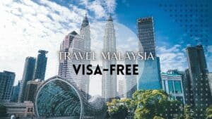 Promotional graphic for visa-free travel to Malaysia featuring the iconic Kuala Lumpur skyline with the Petronas Twin Towers and modern architecture.